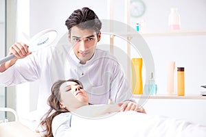 The young woman visiting male doctor cosmetologist