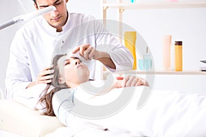 Young woman visiting male doctor cosmetologist