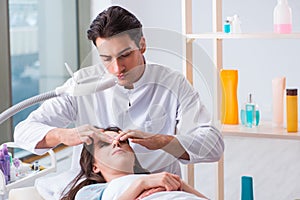 Young woman visiting male doctor cosmetologist