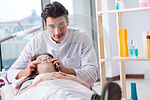 Young woman visiting male doctor cosmetologist