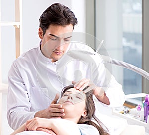 Young woman visiting male doctor cosmetologist