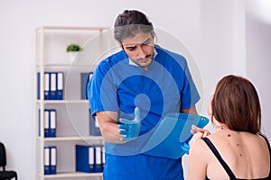 Young woman visiting male doctor dermatologist