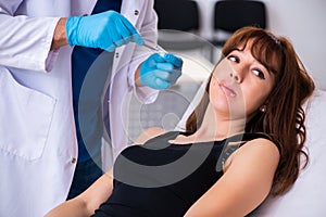 Young woman visiting male doctor dermatologist