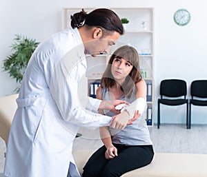 Young woman visiting male doctor traumatologist