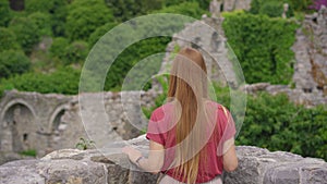 A young woman visits the ruins of the Bar old city or Stari Grad. A destroyed ancient settlement close to the city of