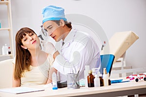 The young woman visting male doctor otolaryngologist