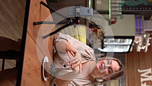 Young woman vlogger recording video for restaurant food channel. Influencer vlogging with her mobile phone mounted on a