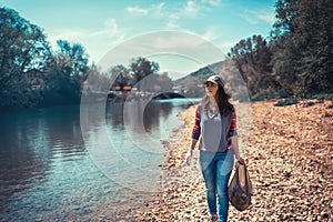 A young woman volunteer with a bag of garbage in her hands is along the river. The concept of Earth Day and ecology and
