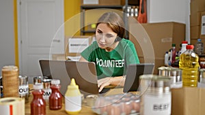 Young woman volunteer using laptop and touchpad at charity center