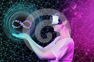 A young woman in VR glasses holding sphere with sign of metaverse. Dark background with abstract mesh and neon lights