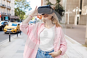 Young woman in VR glasses outdoors