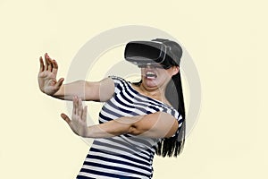 Young woman in vr headset is stratched her hands in fear.