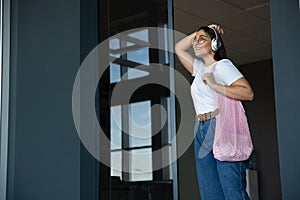 Young woman waiting for departure in airport, traveler with small baggage, influencer`s lifestyle