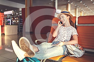 young woman waiting for flying at airport at window with suitcase