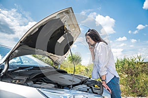 Young woman waiting for help near damaged car