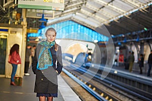 Young woman waiting for a train on the platform of Parisian underground