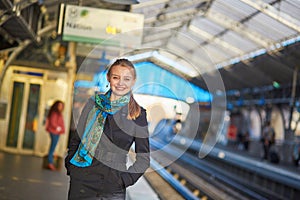 Young woman waiting for a train on the platform of Parisian underground