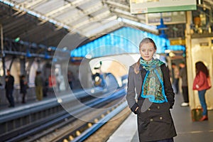 Young woman waiting for a train on the platform of Parisian underground