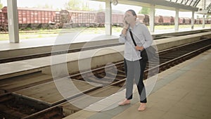 young woman waiting for a train at the station. Joy, excitement, expectation. The masked girl is talking on the phone