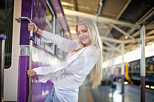 Young woman waiting in vintage train, relaxed and carefree at the station