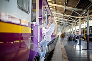 Young woman waiting in vintage train, relaxed and carefree at the station