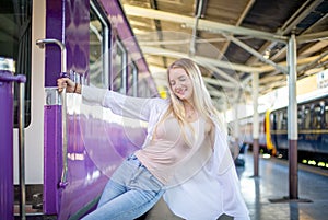 Young woman waiting in vintage train, relaxed and carefree at the station