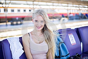 Young woman waiting in vintage train, relaxed and carefree at the station platform in Bangkok, Thailand before catching a train.