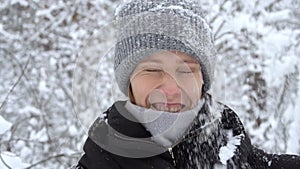 Young woman walk in winter forest and enjoying snowfall. Snow falling on head.