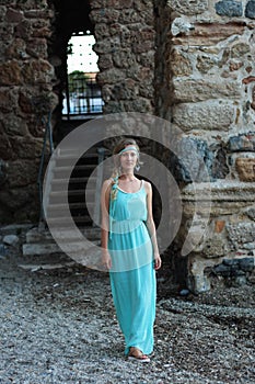 Young woman walking against blurred background of medieval stone