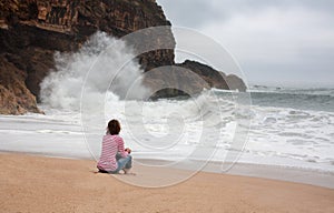 Young woman walking alone on the deserted coast of the Atlantic