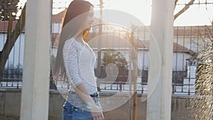 Young woman walking along fountain and smiling