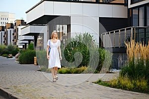 Young woman walking along the pavement in modern residential area