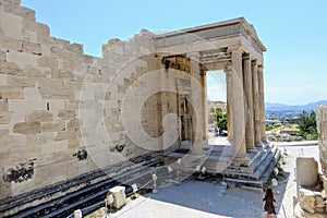 A young woman walking around the Acropolis by herself admiring the glorious ancient Greek Old Temple of Athena atop the Acropolis