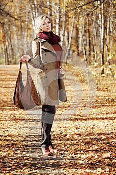 Young woman walking in autumn forest