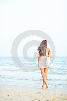 Young woman walking on beach in the evening