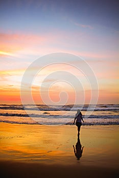 Young woman walking at the beach at sunrise in Ubatuba, Sao Paulo, Brazil