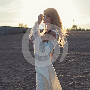 Young woman walking on beach under sunset light,