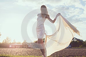 Young woman walking on beach under sunset light,