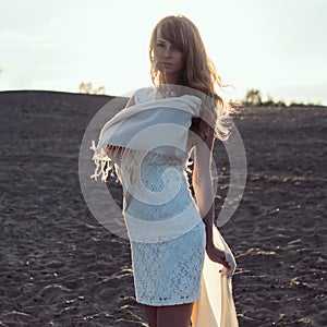 Young woman walking on beach under sunset light,