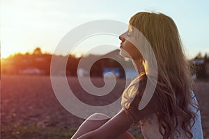 Young woman walking on beach under sunset light,