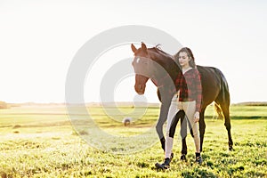 Young woman walking with black horse