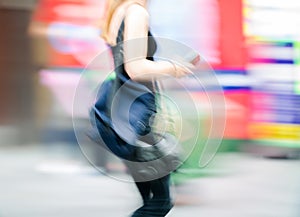 Young woman walking blurred image. Londoners at warm summer day. UK, London
