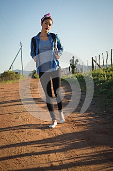 Woman walking on dirt track in countryside