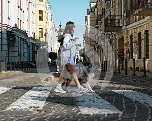 Young woman walking with dog in the town, lifestyle with pets.