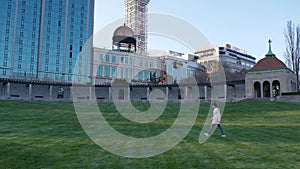 Young woman walking on the grass in front of Sheraton on the Falls Hotel