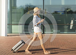 Young woman walking with luggage suitcase at airport