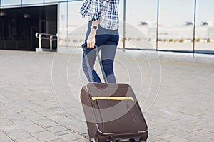 Young woman walking with luggage suitcase, vacations, travel and active lifestyle concept