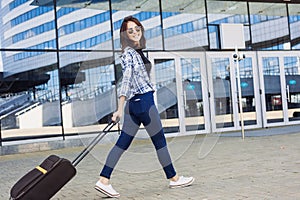 Young woman walking with luggage suitcase, vacations, travel and active lifestyle concept