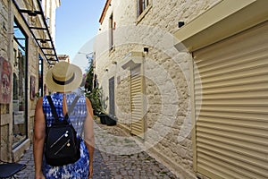 Young woman walking in narrow street in Alacati, Cesme