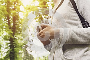 Young woman walking in nature and taking pictures